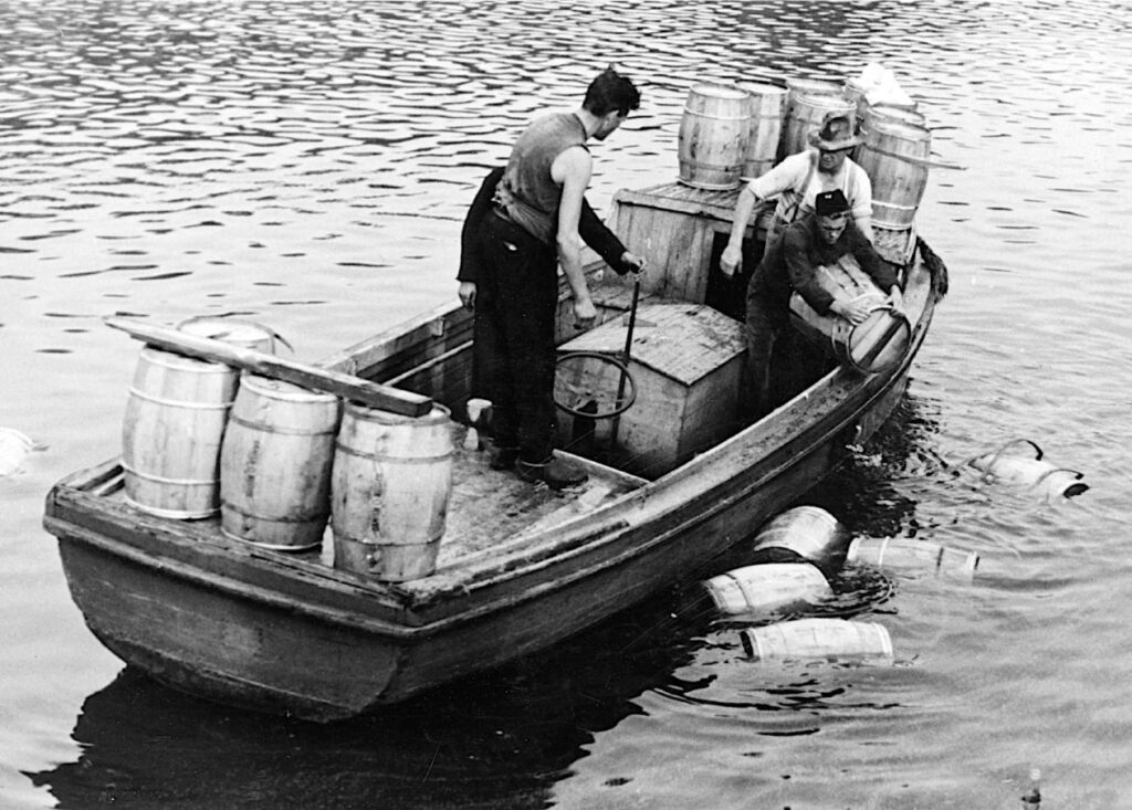 The German steamer, S/S Heyer, operating a regular food shipping service between Odense and Hamburg, was sabotaged in the Odense Havn (‘Port of Odense’) 31 August 1944. The cargo of butter, seed and condensed milk was scattered in the port basin. In the photo the men are recovering casks of butter