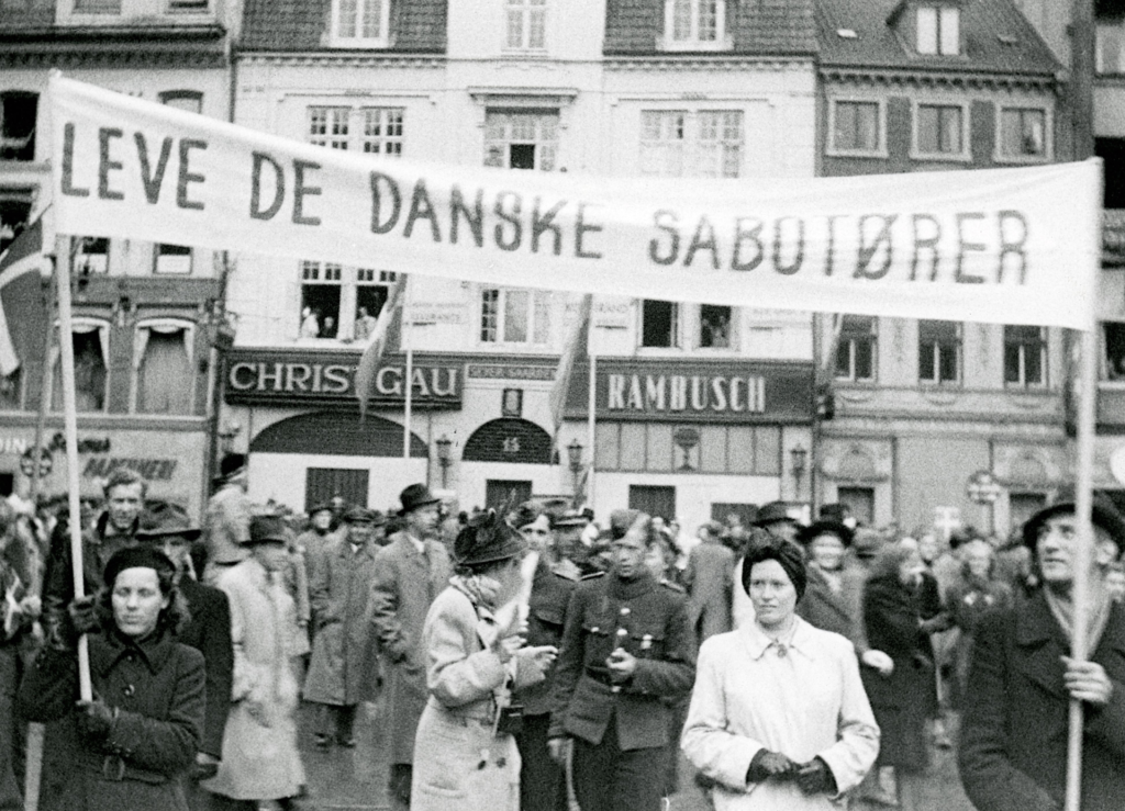 Die dänische Besetzung und Befreiung: 13. Dänemark ist wieder frei: Die Befreiung wird am 5. Mai 1945 in Odense gefeiert. Das Banner lautet: Lang leben die dänischen Saboteure