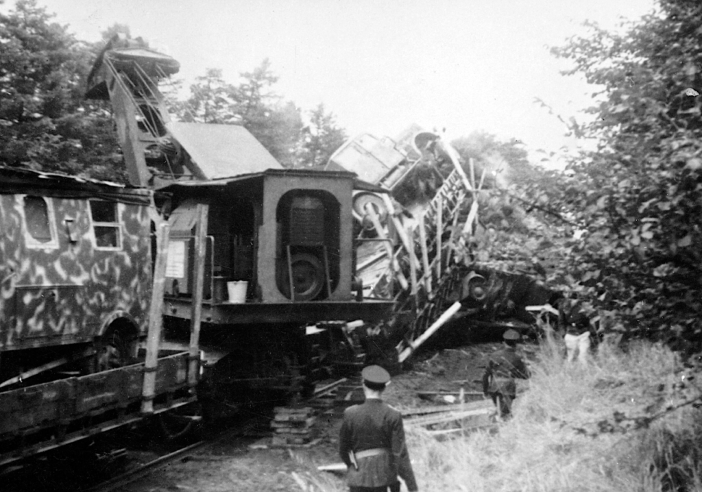Besættelsen og befrielsen: 10. Jernbanesabotage: Sabotage mod tog med biler mellem Herning og Karup Flyveplads i 1944. En kran er i gang med at rydde sporet