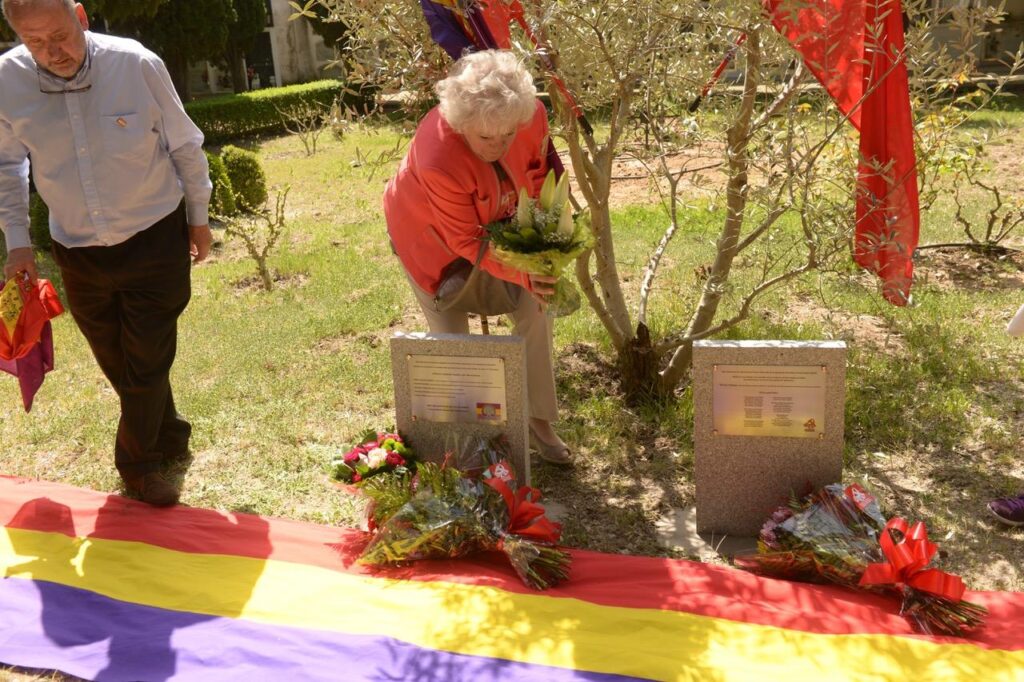 Mario Kloostra's cousin Corrie Triep (Kind von Arie Kloostras Schwester) legt nach der Enthüllung des Denkmals auf dem Friedhof San Esteban de Letera im April 2015 Blumen auf die Gedenktafeln